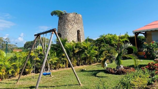 Altalena in un giardino con una torre di pietra sullo sfondo.