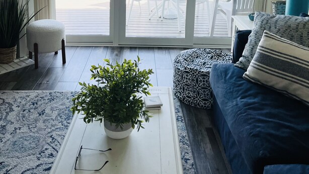 Ein Wohnzimmer mit einem großen Schiebeglastür, die auf eine Terrasse im Freien führt.