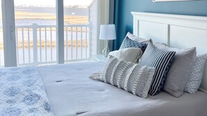 Ein Schlafzimmer mit einem großen Bett, Blick ins Freie und einem Schild an der Wand.
