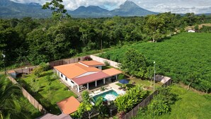Una casa con piscina, immersa nel verde e con vista su una montagna.
