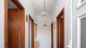A hallway with wooden doors and a tiled floor. - A1 - apt near beach with patio, parking and grill  (Stobreč)