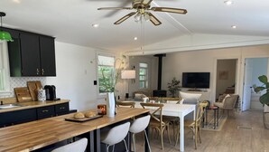 Eine moderne Küche mit einer Holzinsel, Barhocker und einem Deckenventilator.