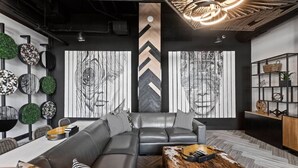 Una sala de estar moderna con un sofá modular, una mesa de centro y una pared decorada con arte abstracto.