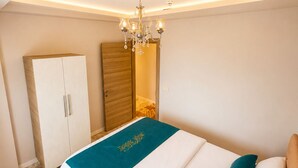 Un dormitorio con cama, armario, espejo y candelabro.