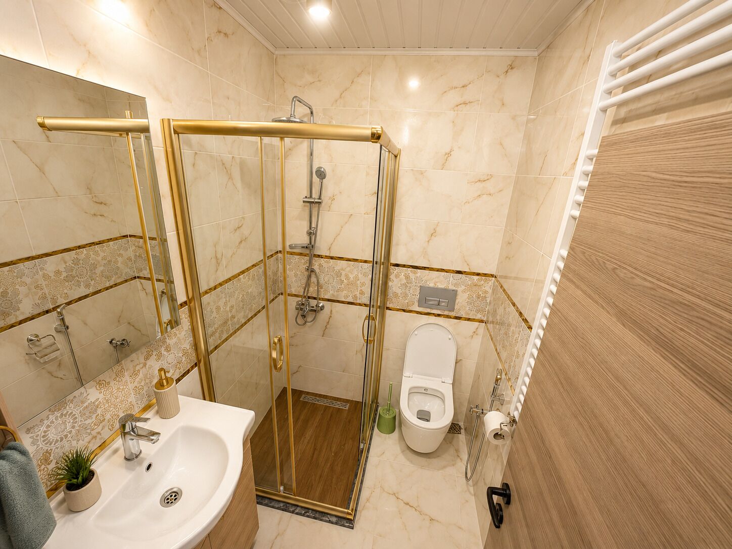 A bathroom with a glass-enclosed shower, a sink with a mirror, and a toilet.