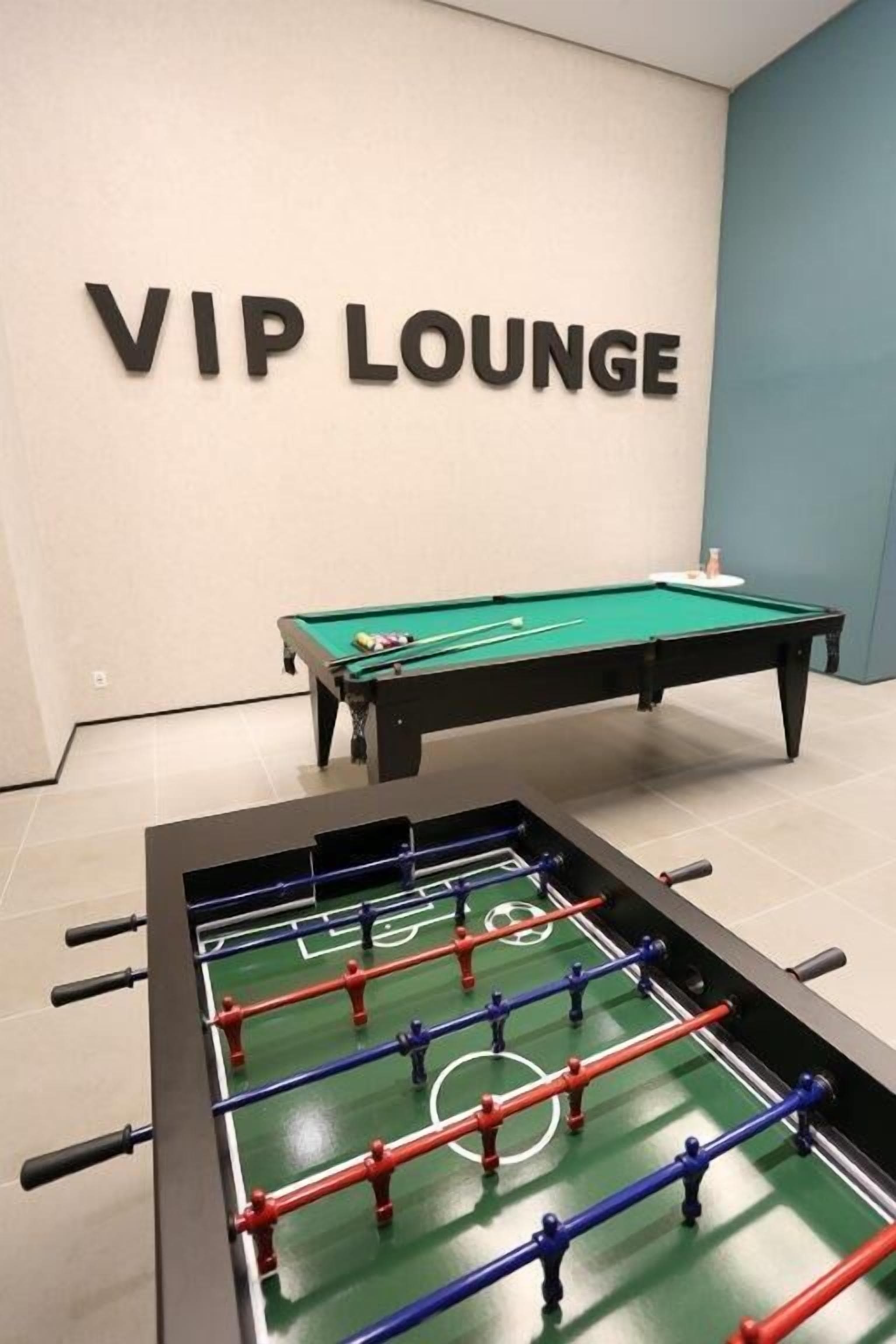 A VIP lounge with a pool table and a foosball table.