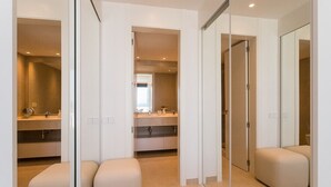 Un baño moderno con un espejo grande, un lavabo y un inodoro.