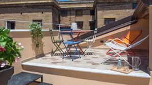A rooftop terrace with a table, chairs, and a potted plant. - Le Niche Holiday Home - Terrace by Wonderful Italy (Palermo)