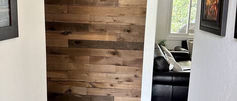 Un pasillo con pared de madera y suelo de madera oscura.