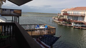 A waterfront property with a deck, outdoor seating, and a view of the water. - North Padre Island waterfront canal  home w/private dock and pool (Corpus Christi)