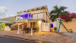 A hotel with a two-story structure, a covered outdoor seating area, and a gated entrance. - Victoria House (Frederiksted)