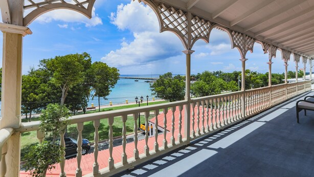 A covered balcony with a view of a body of water and a bridge. - Victoria House (Frederiksted)