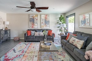 A living room with two sofas, a coffee table, and a ceiling fan. - Colorful Desert Hideaway: Heated Pool & Hot Tub (Scottsdale)