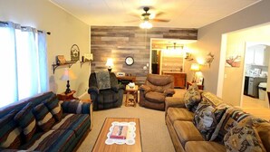 Una sala de estar con sofá, sillones, una mesa de centro y una chimenea.