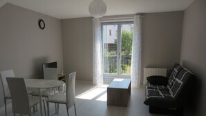 Een moderne woonkamer met een eethoek, een bank en een salontafel.