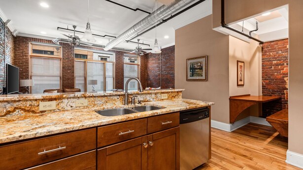 A kitchen with granite countertops, stainless steel appliances, and wooden cabinets. - The Johnny Cash Dual Condos Downtown at Printer's Alley & Steps to Broadway (Nashville)