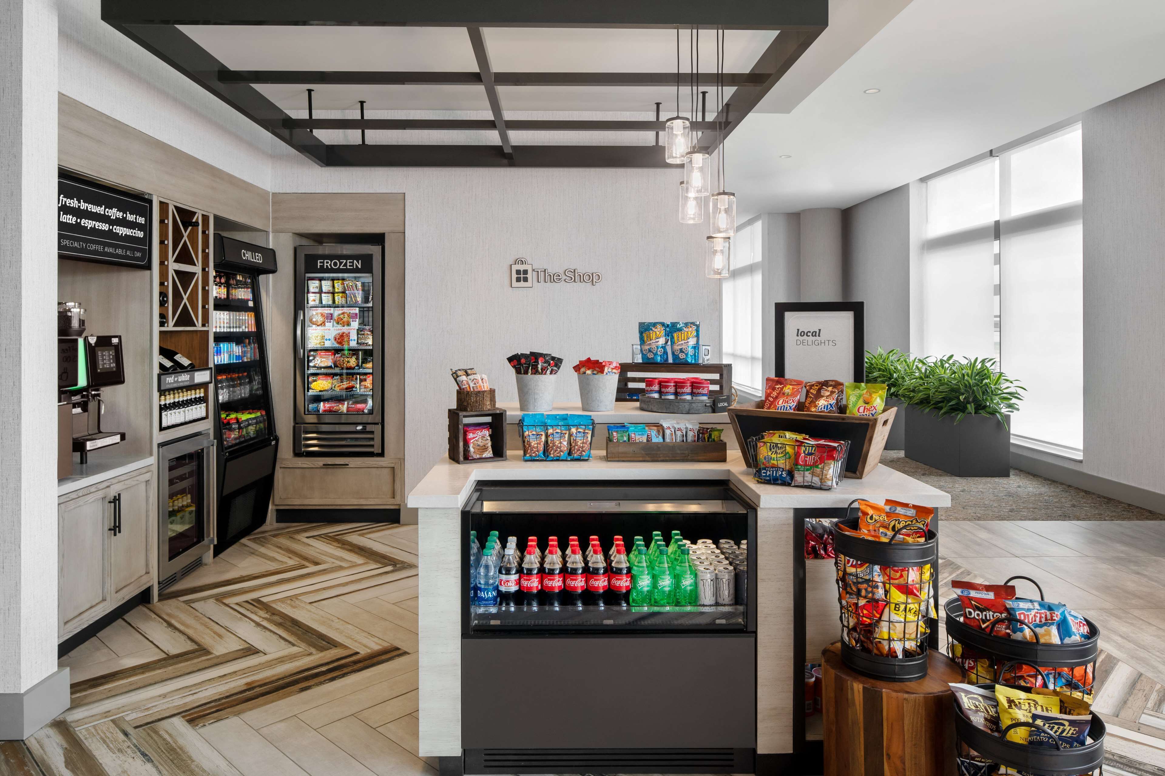 Un espace de vente moderne doté de distributeurs de boissons réfrigérés, de présentoirs à collations et d’un assortiment de spécialités locales.