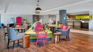 A modern hotel lobby with seating areas, a reception desk, and a "HOME2" sign. - Home2 Suites by Hilton Largo (Largo)