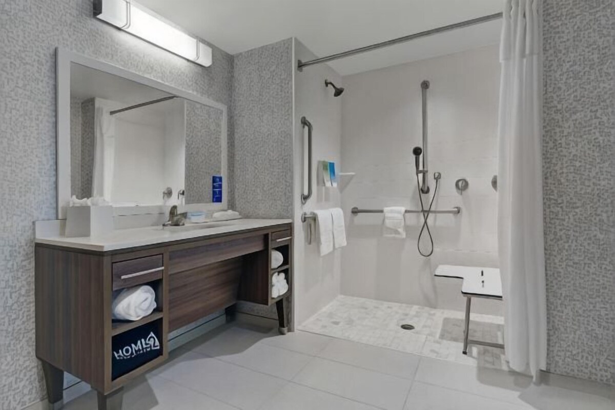 A modern bathroom with a shower, sink, and vanity.