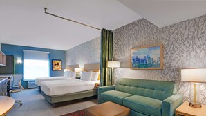 A hotel room with two beds, a sofa, a desk, and a chair. - Home2 Suites by Hilton Largo (Largo)
