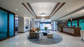Eine großzügige Lobby mit Empfangsbereich, Sitzgelegenheiten und einer imposanten Chandelier.