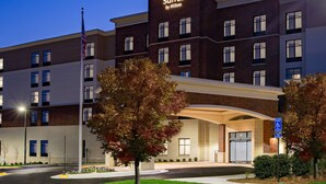Ein Hotel mit einem gut sichtbaren Schild, das "Homewood Suites by Hilton" zeigt, einer Ziegel-Fassade und einem überdachten Eingang.