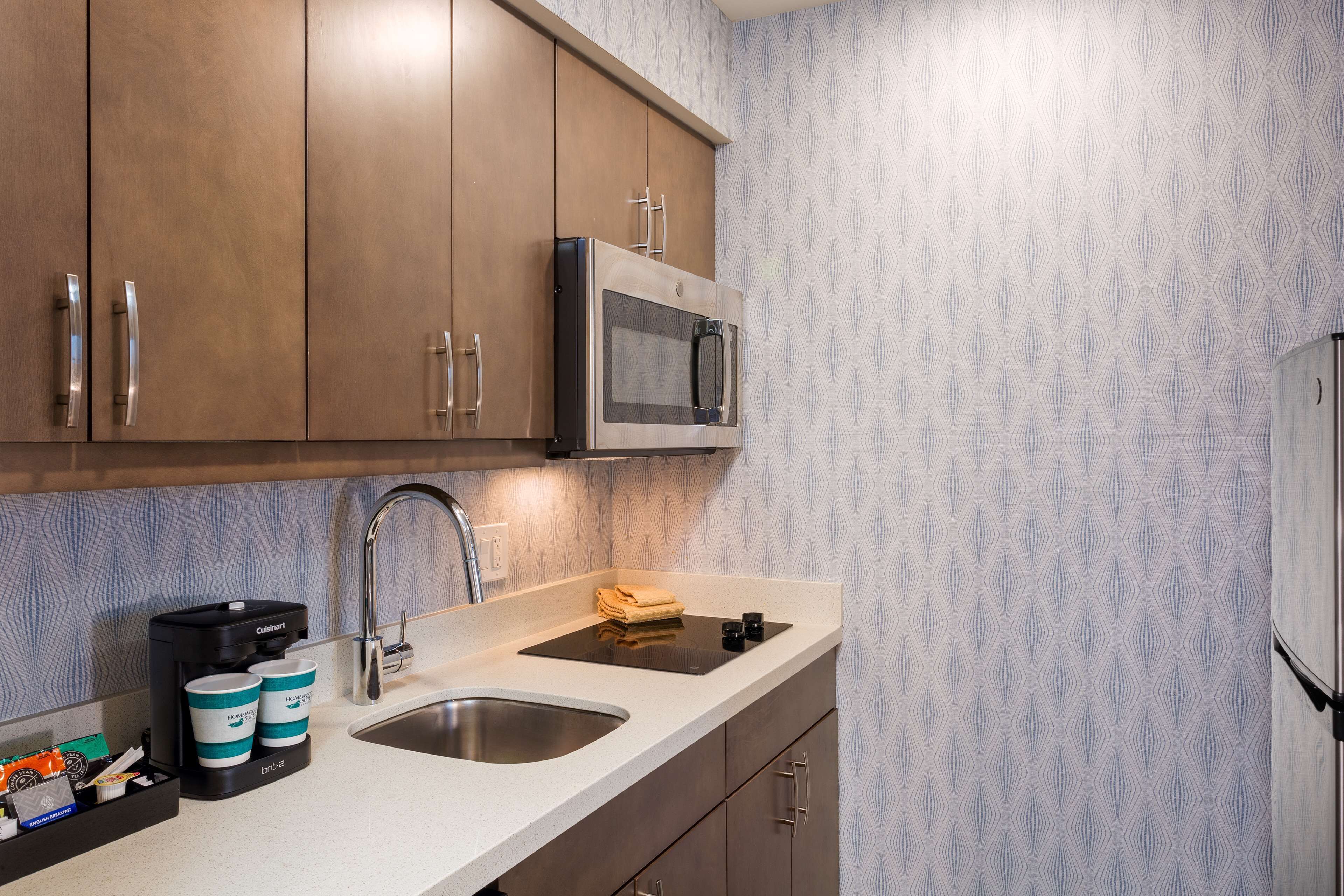 A kitchen with a double sink, stainless steel appliances, and a coffee maker.