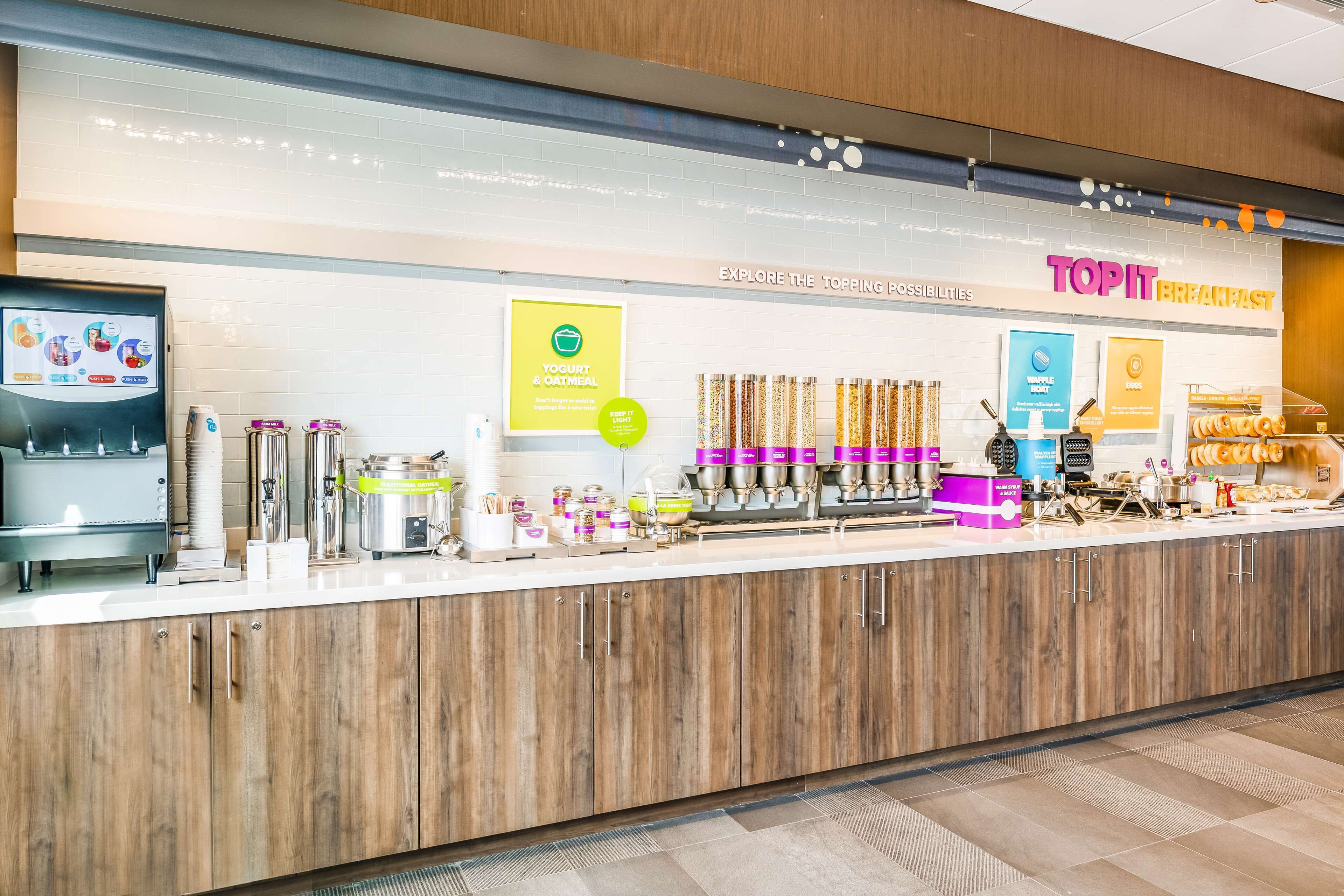 A breakfast counter with yogurt and oatmeal options, a coffee machine, and a variety of breakfast items.