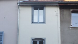 A two-story building with a light-colored facade and three windows with blue frames. - 4 to 6 berth accommodation 10 mi walk from the lake (Clairvaux-les-Lacs)