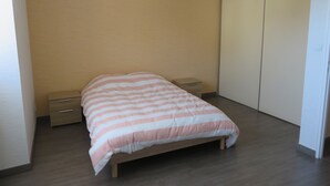 A bedroom with a bed, two bedside tables, a wardrobe, and a small drawer unit. - 4 to 6 berth accommodation 10 mi walk from the lake (Clairvaux-les-Lacs)