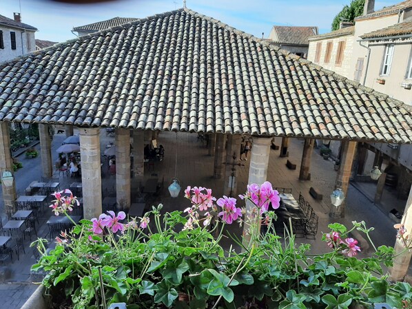 A courtyard with a tiled roof, stone columns, and outdoor seating.