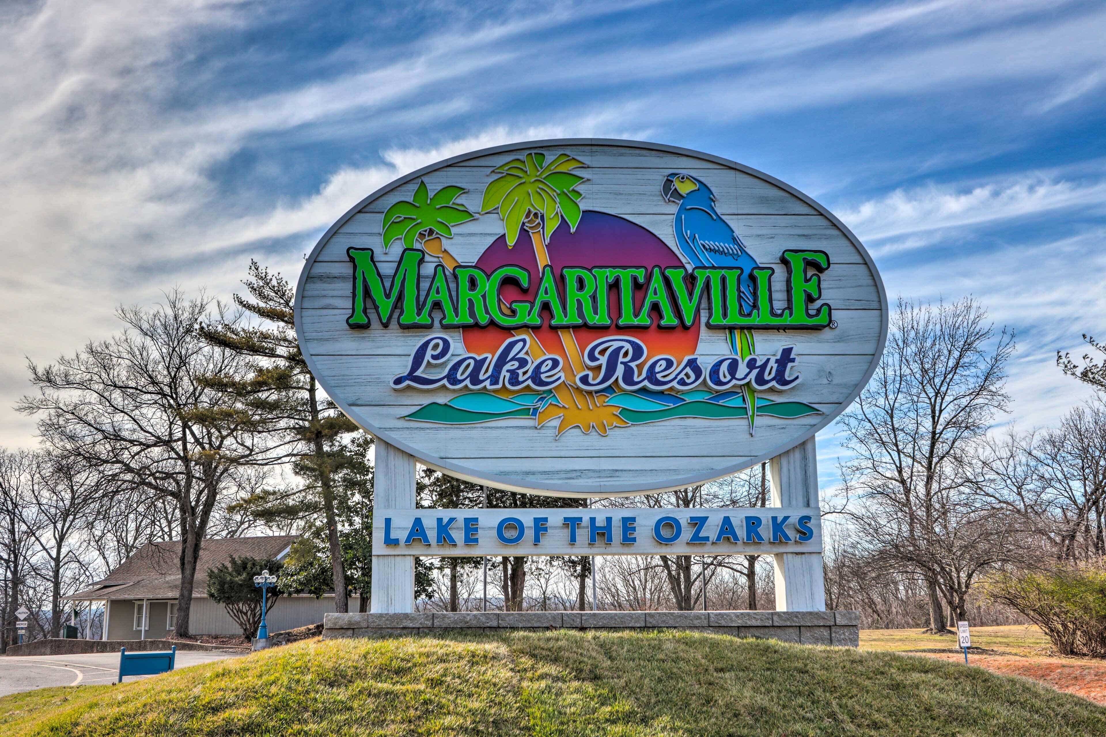 A large, wooden sign for Margariaville Lake Resort with palm trees and a bird illustration.