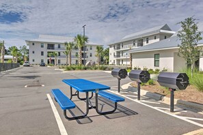 A parking area with a blue picnic table and barbecue grills. - 'Salt & Serenity on 30A' Walk to Santa Rosa Beach! (Santa Rosa Beach)