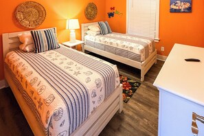 Two single beds with striped bedding, a bedside table with a lamp, and a small white cabinet. - 'Salt & Serenity on 30A' Walk to Santa Rosa Beach! (Santa Rosa Beach)