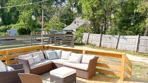 A wooden deck with wicker furniture, including a sofa and chairs. - Vintage Cottage in Wanchese (Wanchese)