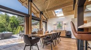 A modern kitchen with a wooden table and chairs, a large window, and a view of the outdoors.