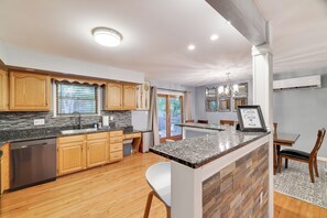 Una cocina moderna con armarios de madera, encimeras de granito y lavavajillas integrado.