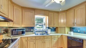 A kitchen with wooden cabinets, a microwave, a sink, a stove, and a dishwasher. - Spacious Lake Hartwell Home w/ Private Boat Dock! (Anderson)