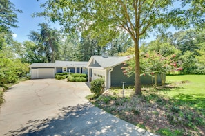 Set amidst a lush green environment, this two-story house offers a peaceful retreat with a driveway and a spacious garage.