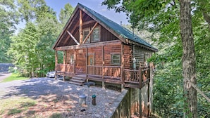 Eine Blockhütte mit Veranda, umgeben von Bäumen.