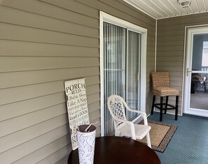 Relax on the porch with two comfortable chairs and a small table, perfect for socializing or unwinding.