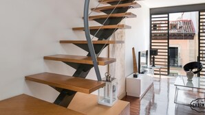 Una escalera espiral moderna con peldaños de madera y barandillas de metal.