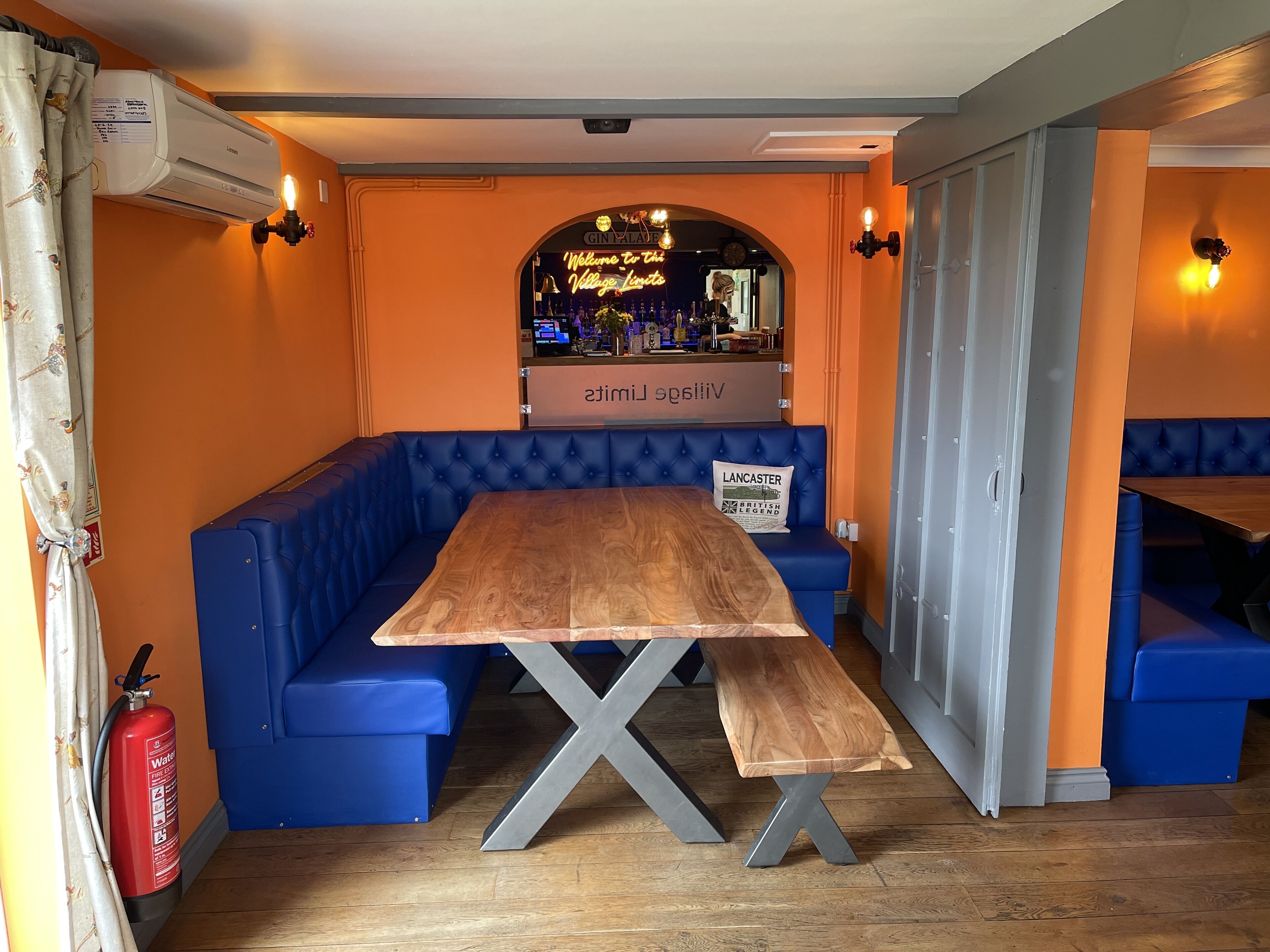 Un restaurante con mesa de madera y asientos acolchados azules.