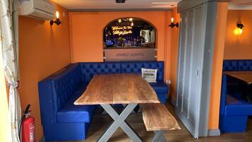 Un restaurante con mesa de madera y asientos acolchados azules.