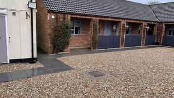 A building with a tiled roof, brick walls, and a gravel driveway.