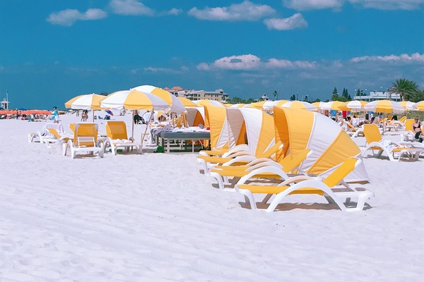 Ranta lähistöllä, aurinkotuoleja, rantapyyhkeitä