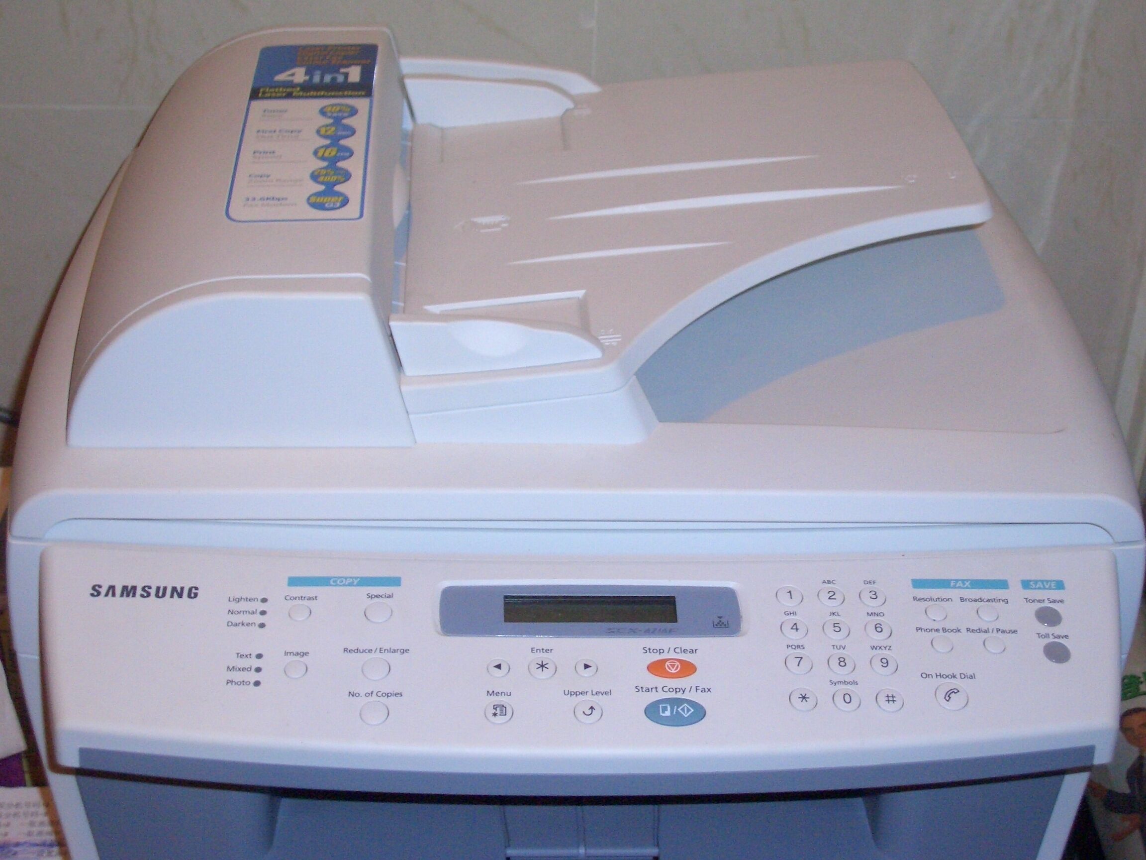 A Samsung multifunction printer with a control panel, including options for copy, fax, and save functions.