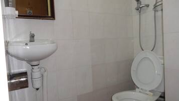A bathroom with a white sink, toilet, and shower.