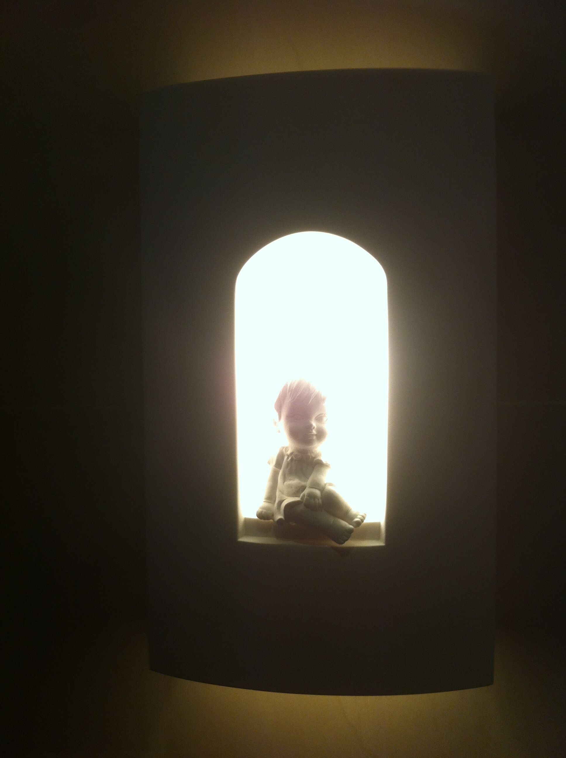 A wall-mounted light fixture with a silhouette of a child.