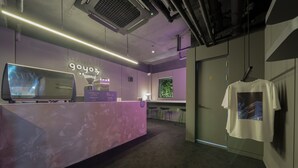 A modern reception area with a marble counter, a television, and a sign that reads "9oyo3". - Goyo37 Hotel Osan by Anook (Osan)